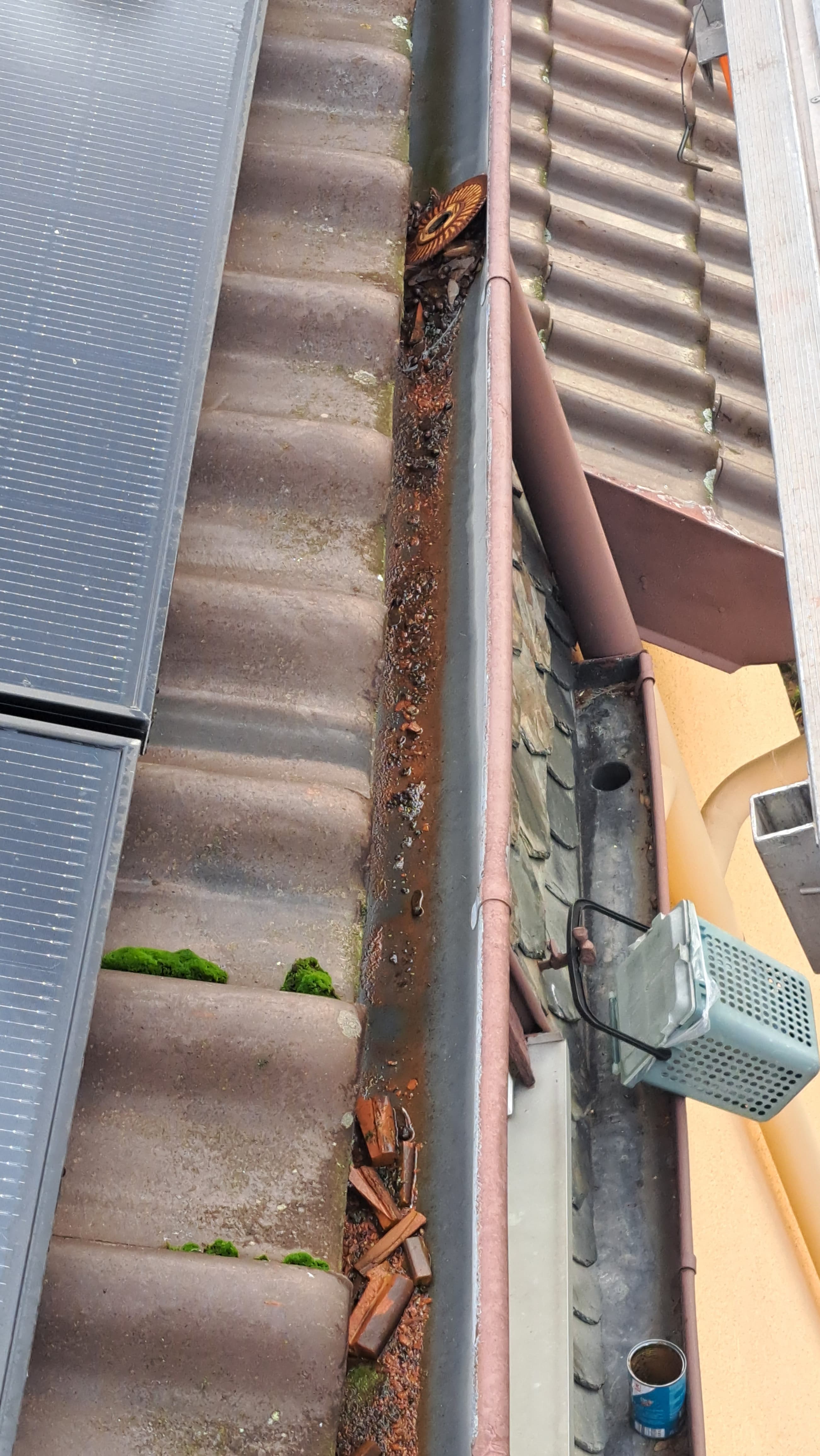 Dachrinne voller Ziegel-Schnittreste und einer liegen gelassenen Trennscheibe nach Solarmontage